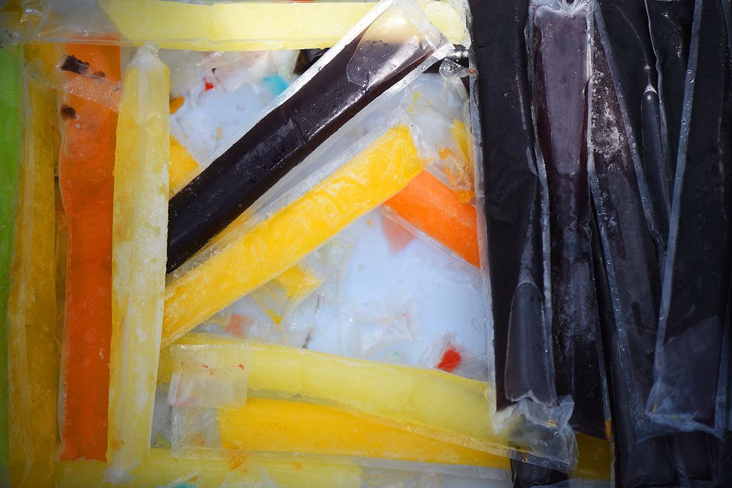 Popsicles sit in an ice box